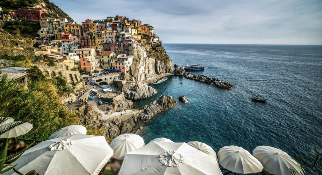 Colorful cliffside village above the sea on a scenic coastal walking route.