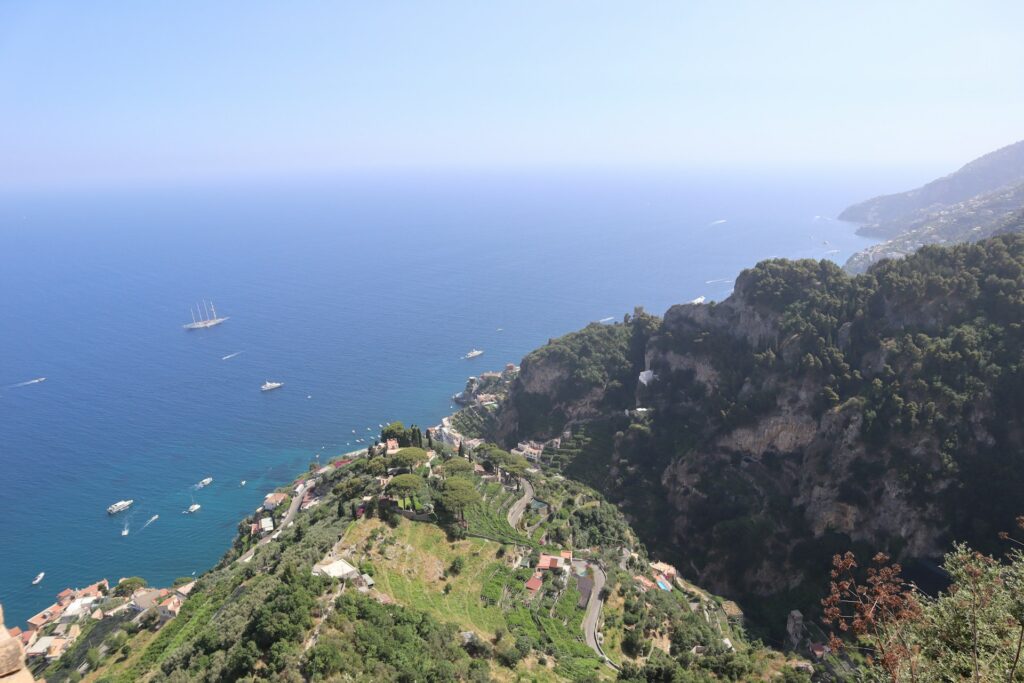 Elevated view of green hills, cliffs, and the sea along an Amalfi Coast hiking route.