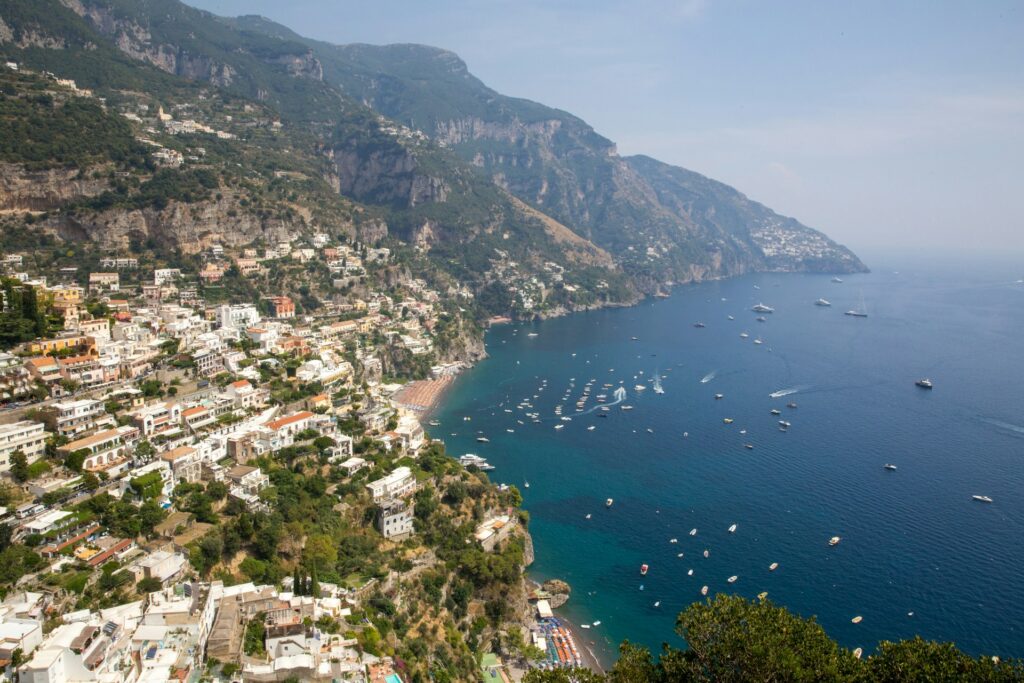 High viewpoint overlooking a hillside town, beach, and boats along the Amalfi Coast.